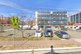 Street view of Columbia Pike near Abol Ethiopian Market, showing the crosswalk and on-street parking