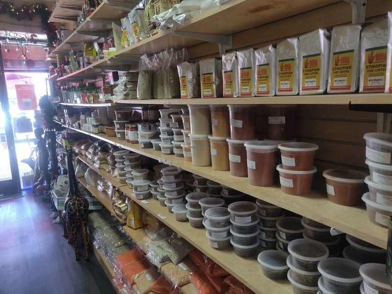 Shelves of Ethiopian fine coffee bags above rows of tubs of ground spices, teff and pulses