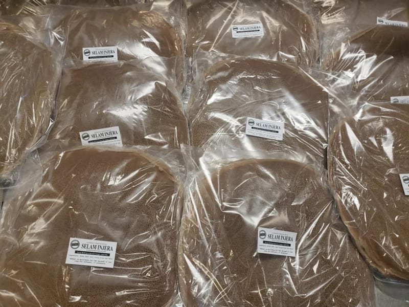 Stacks of fresh injera sealed in labelled packs, ready to take home