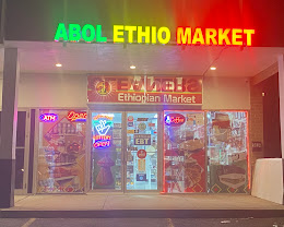 The lit storefront of Abol Ethiopian Market on Columbia Pike in Falls Church at night